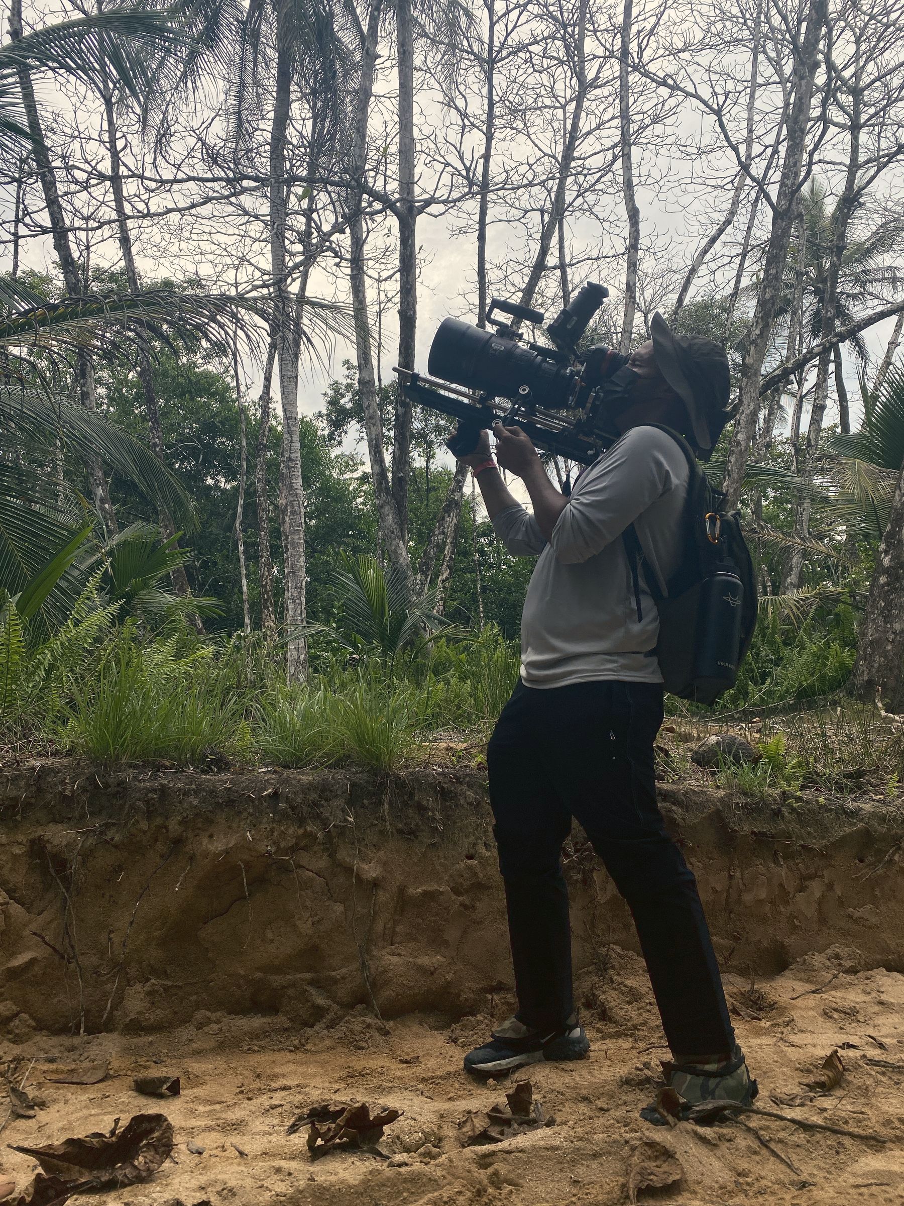 Camera operator filming in dense Caribbean rainforest